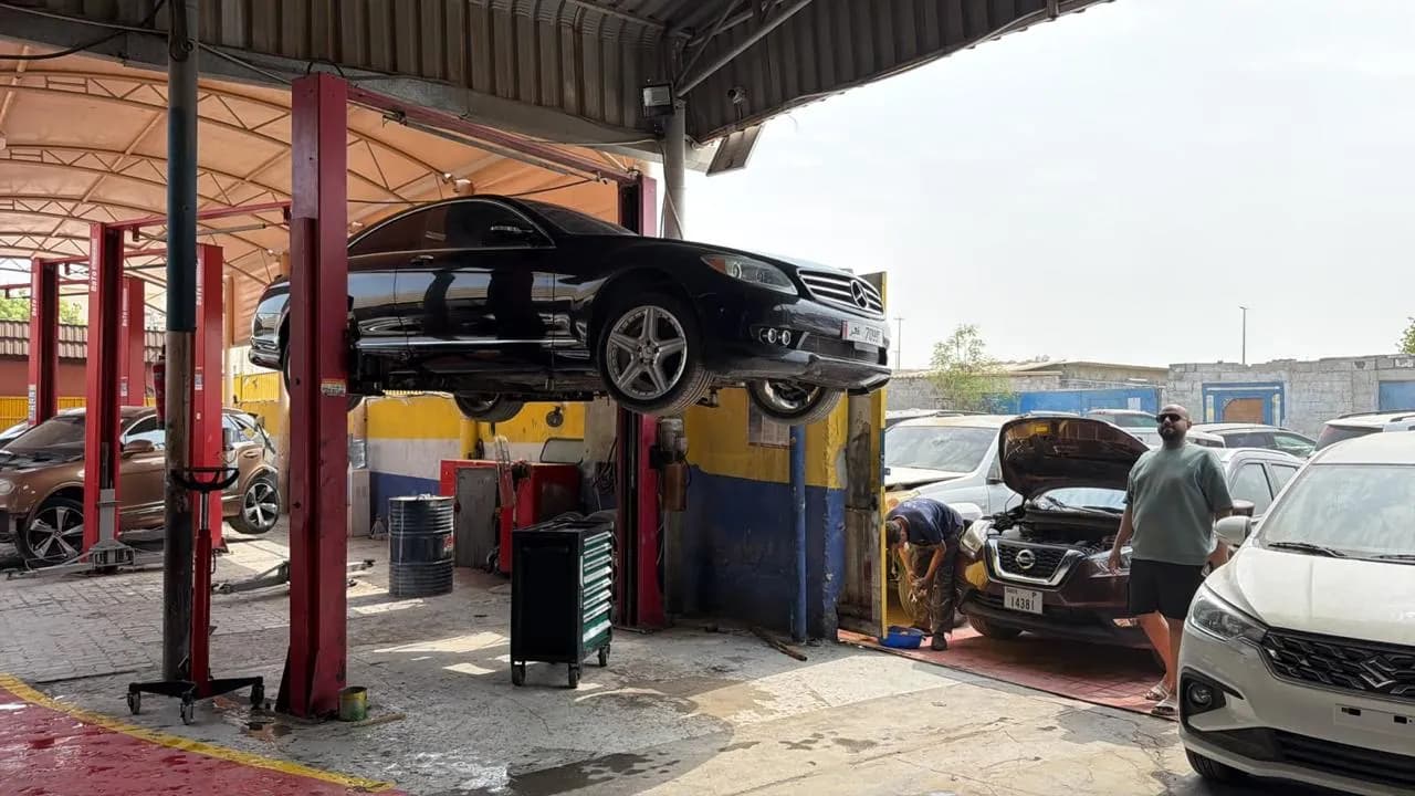 فنيون يعملون على سيارة مرفوعة